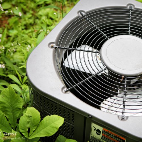 Air Conditioner installation in garden next to house.